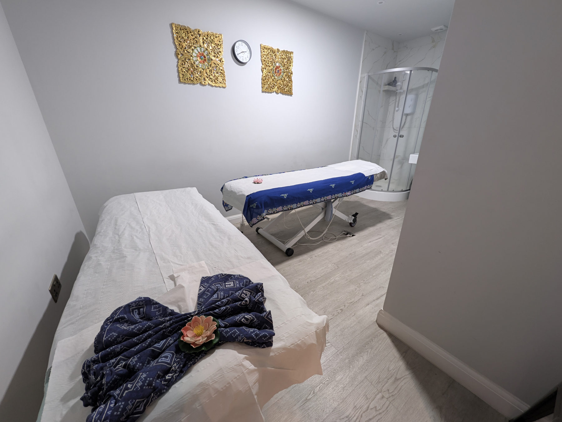 Two prepared massage beds with blue Thai textiles
