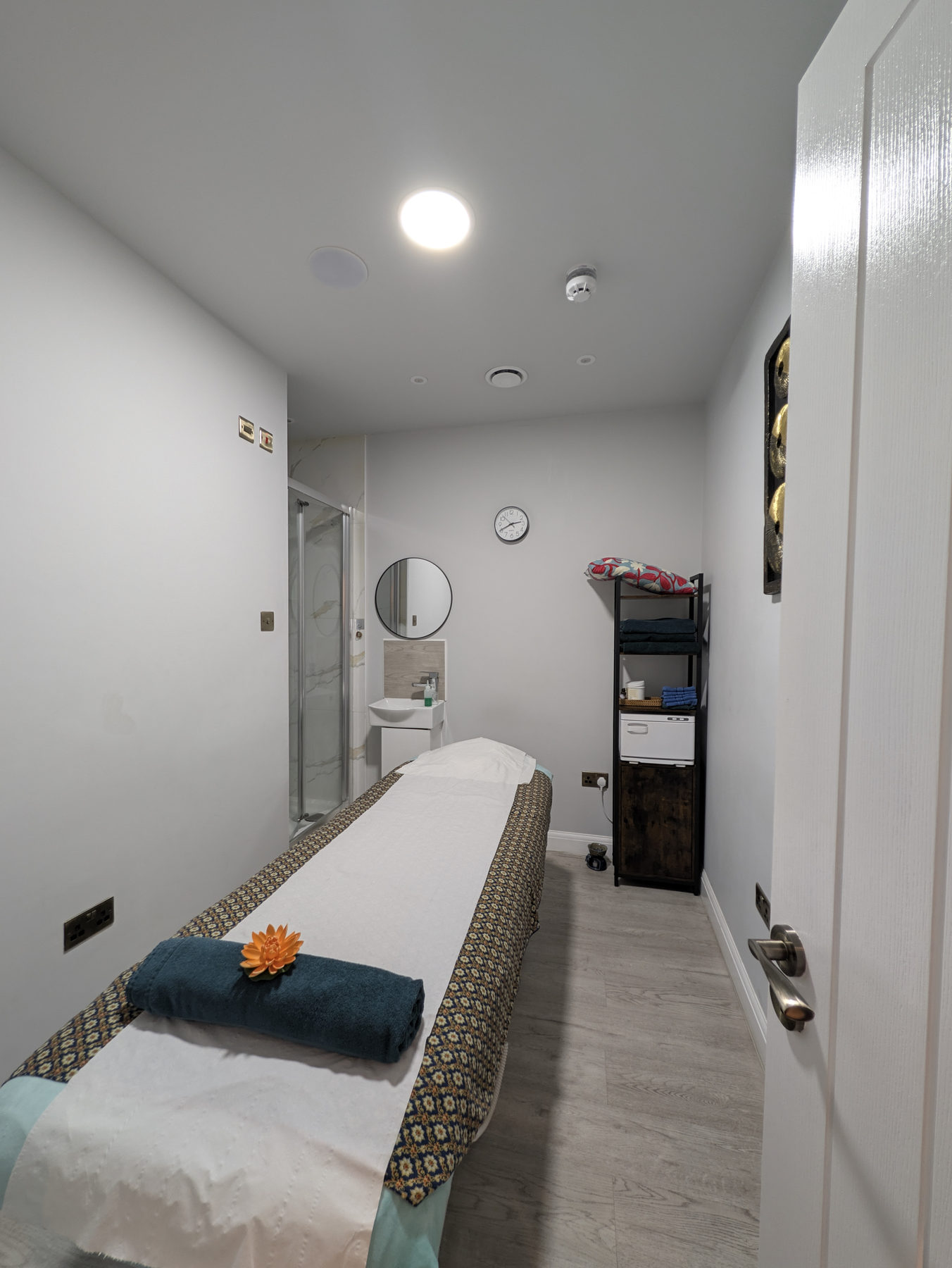 A prepared private massage room with a treatment bed